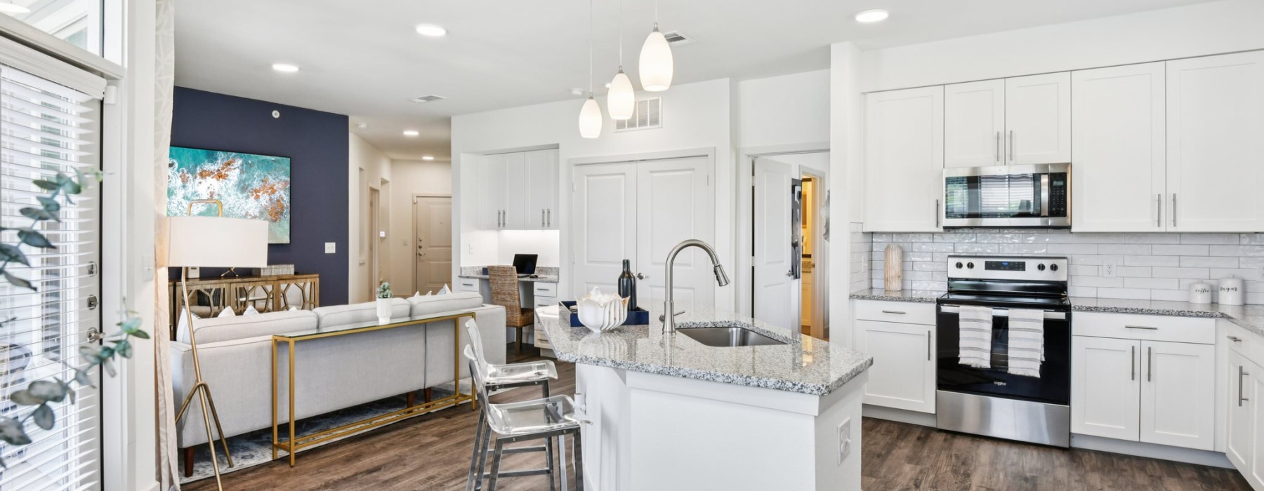 a kitchen with white cabinets and granite countertops and a kitchen island