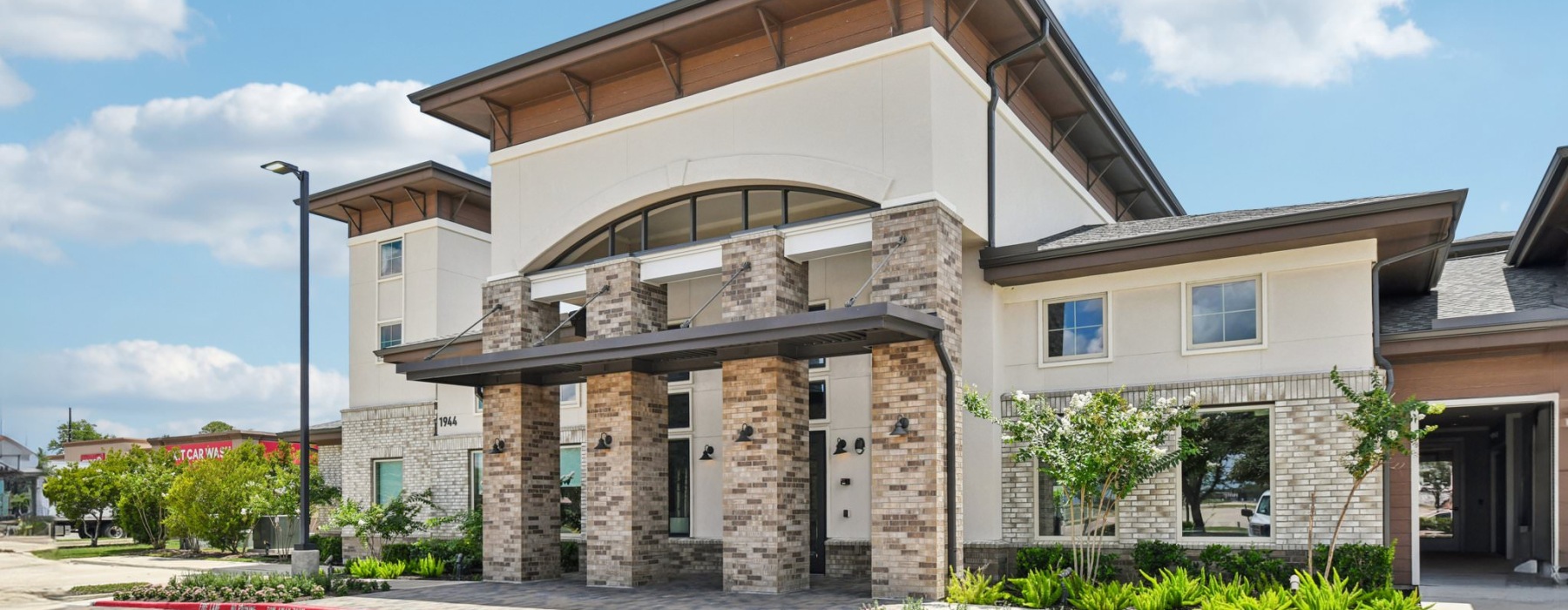 a brick building with lush landscaping around