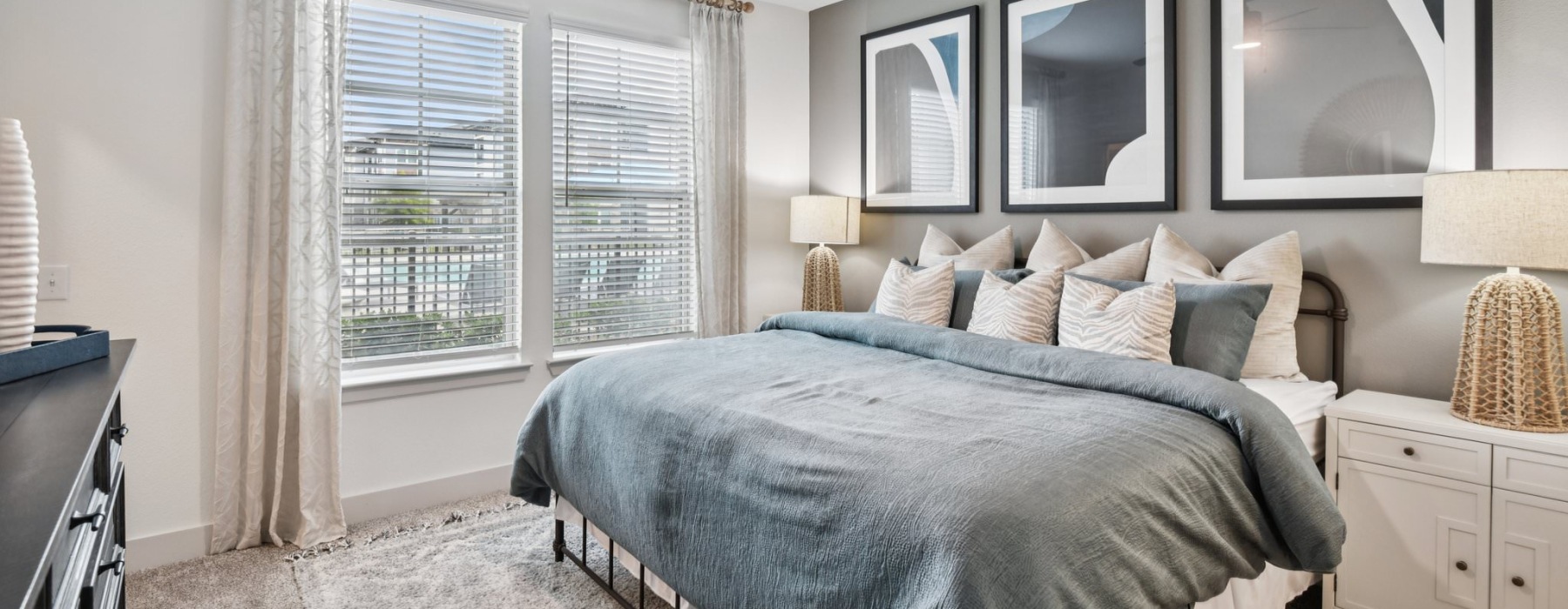 bedroom with large windows and night stands with lamps