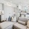 a living room and work area leading into a kitchen with white cabinets
