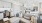 a living room and work area leading into a kitchen with white cabinets