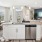 a kitchen with a large island with a sink and dishwasher with a dining area