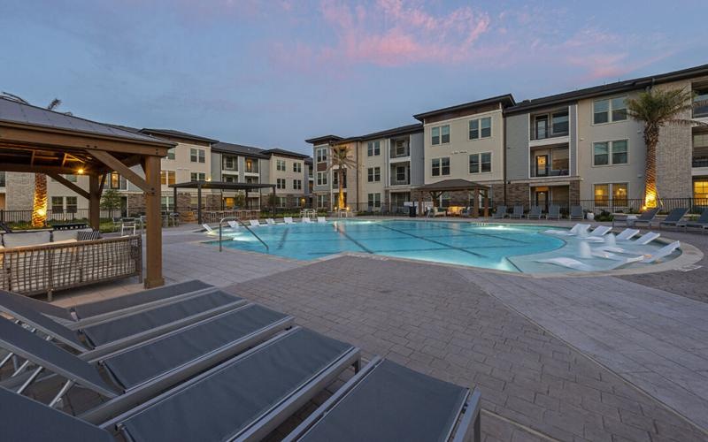 a swimming pool in  courtyard with lounge chairs